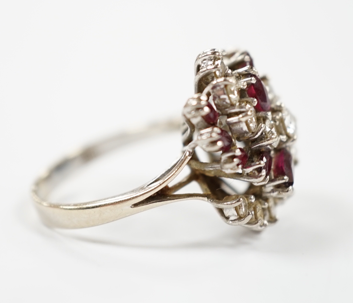 An 18ct, ruby and diamond set spiral cluster ring, size O, gross weight 7.7 grams.